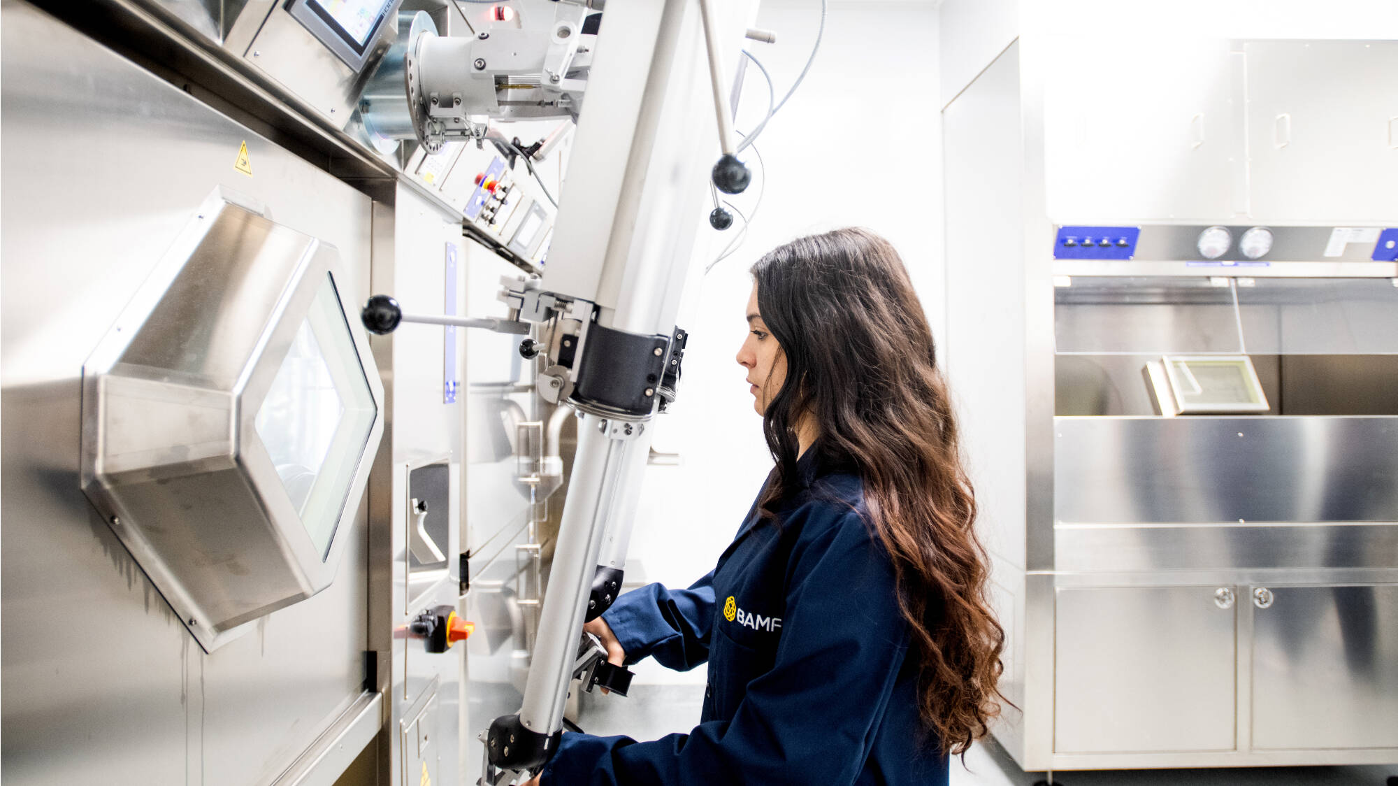 Samantha Spurr uses manipulator arms to work in a research hot cell at BAMF Health.